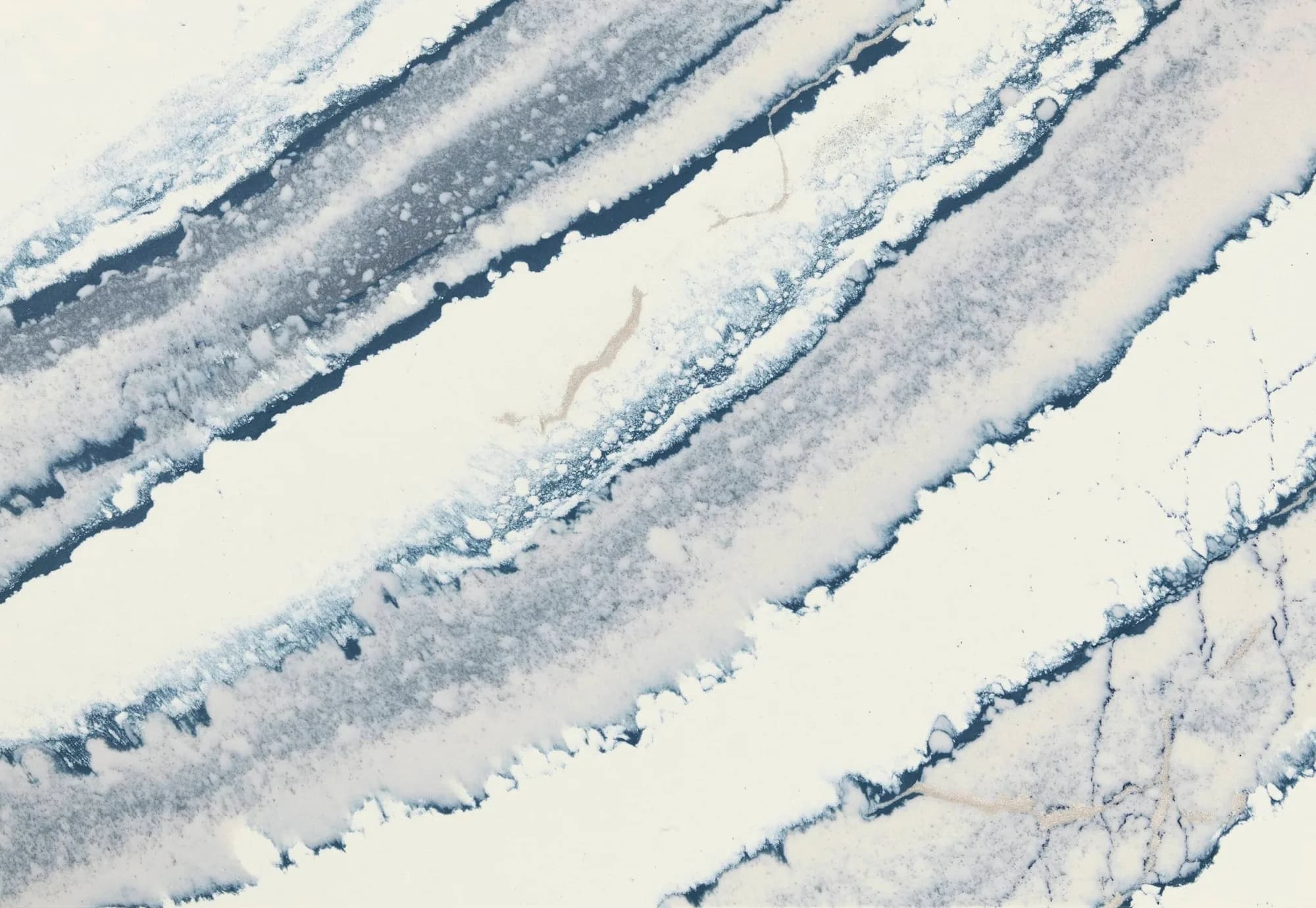 Close-up view of Cambria Inverness Bristol Bay Quartz countertop featuring stormy-blue waves, cool white backdrop, and debossed Inverness veins, showcasing its high gloss finish and durability for residential and commercial applications.