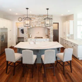 Brittanicca Warm Cambria Quartz Kitchen Countertops and Island with Cream Cabinets White Cabinets Pendant Lighting