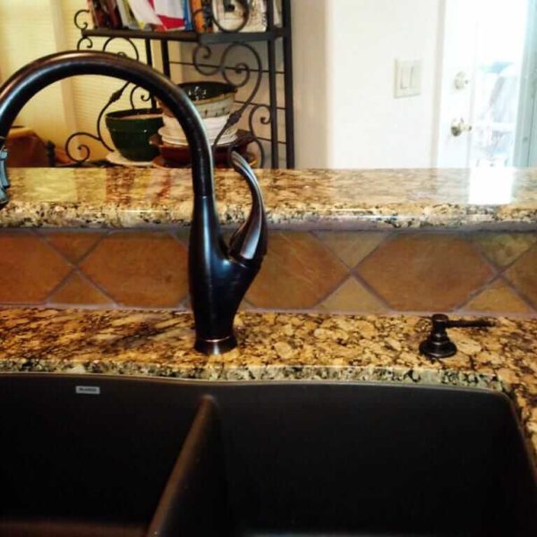 Giallo Fiorito Granite Installed with an Undermount Sink and Black Faucet