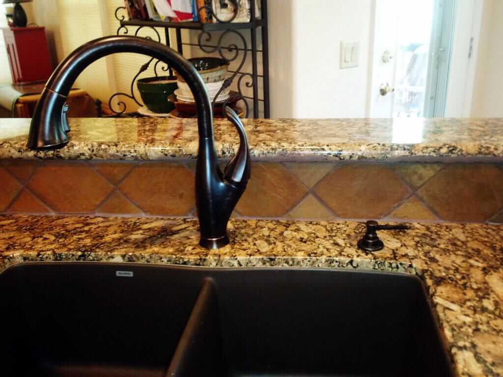 Giallo Fiorito Granite Installed with an Undermount Sink and Black Faucet