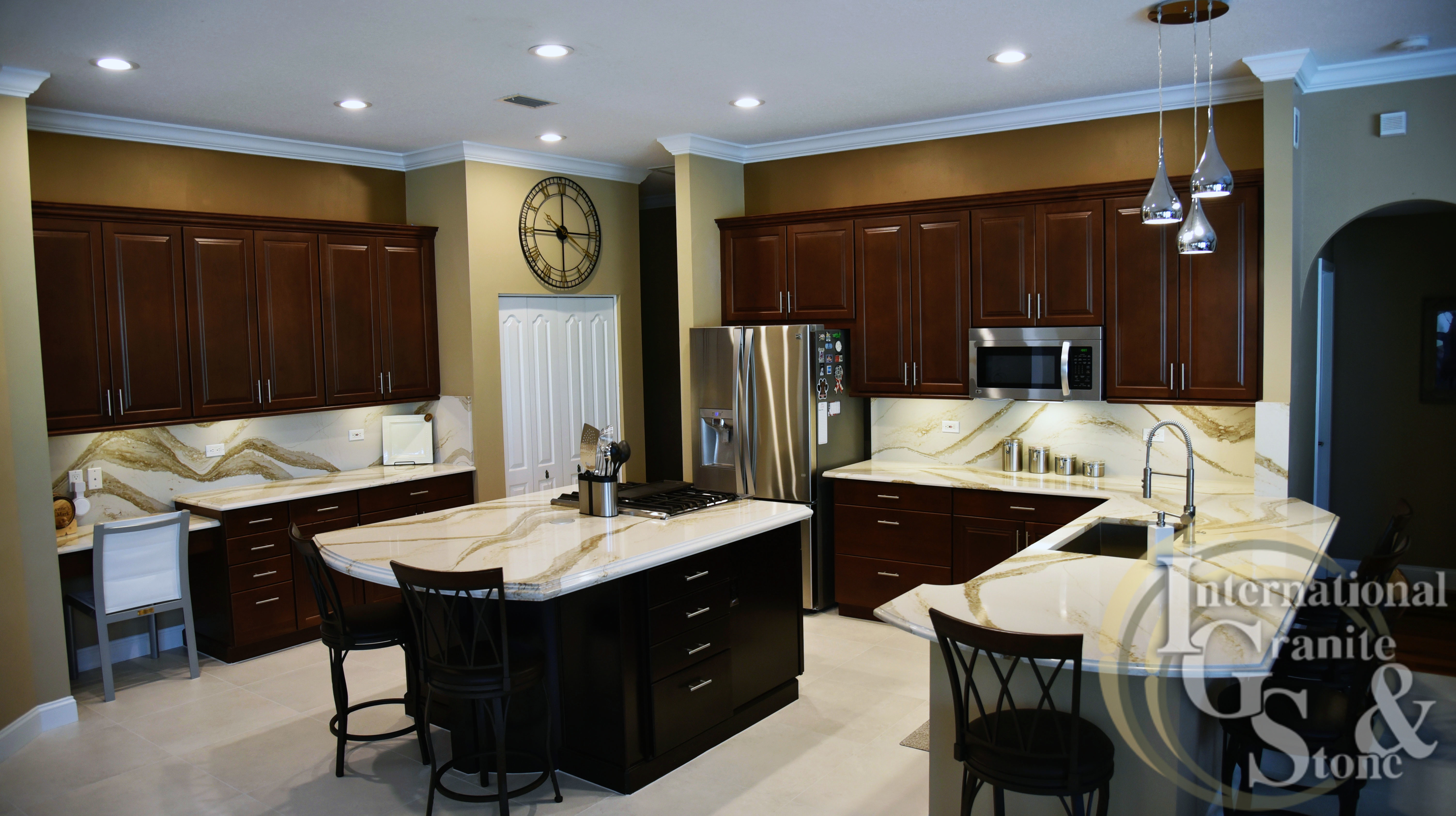 Light Cambria Quartz Countertops with Dark Cabinets Brittanicca Gold Black Cabinets Brown Cabinets Stainless Steel Appliacnes