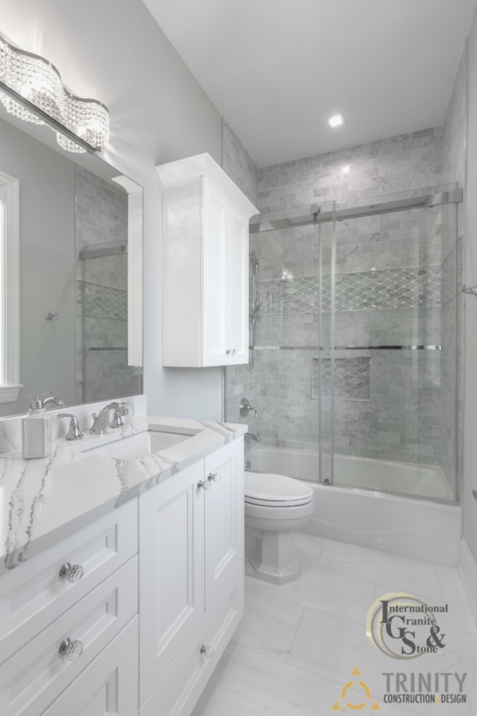 Light White Bathroom with Brittanicca Quartz Countertops and Gray Tile Backsplash Walls in Shower